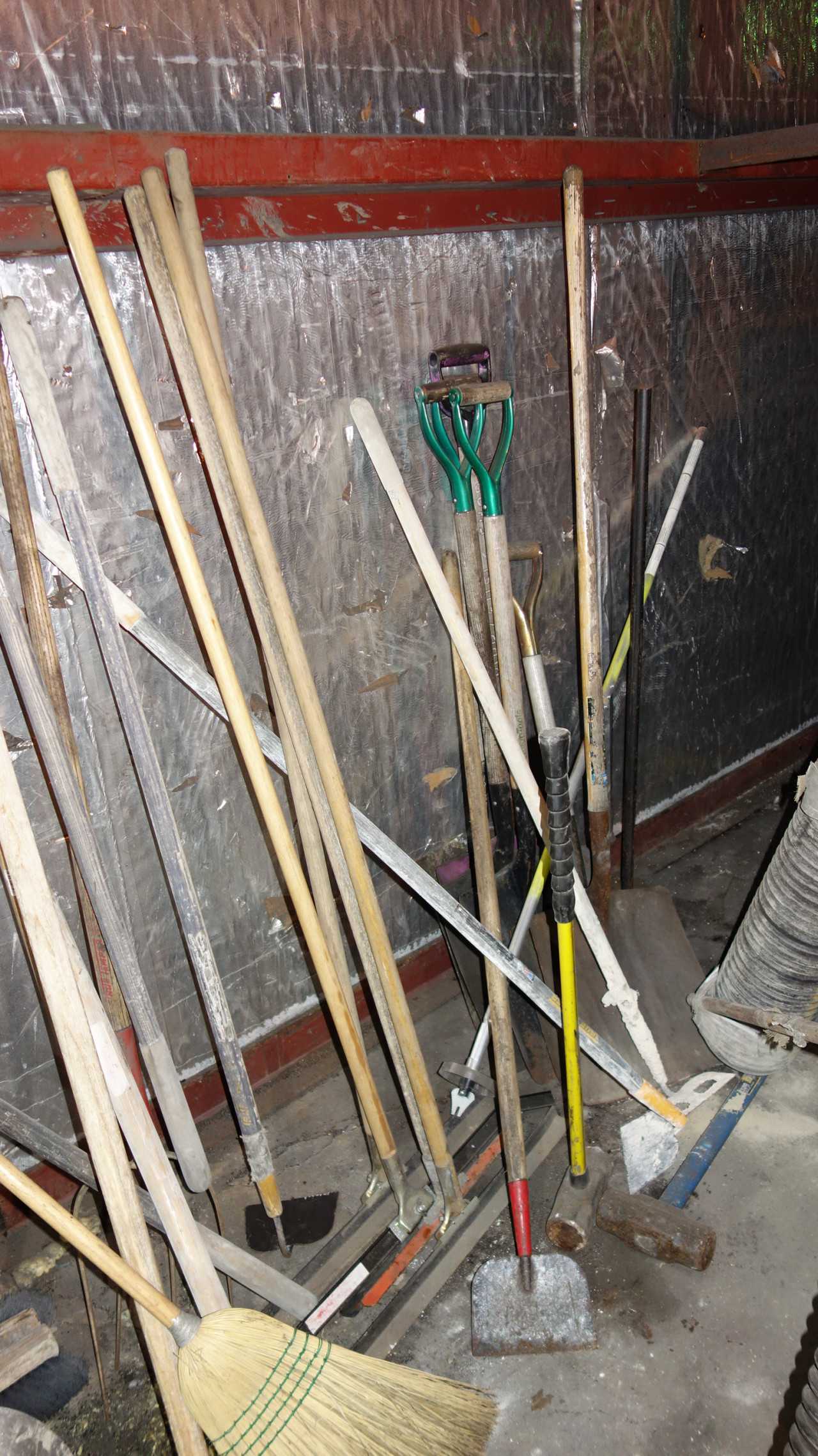 LOT OF BROOMS, SHOVELS, HOES AGAINST WALL - ELECTRIC POWER TOOLS