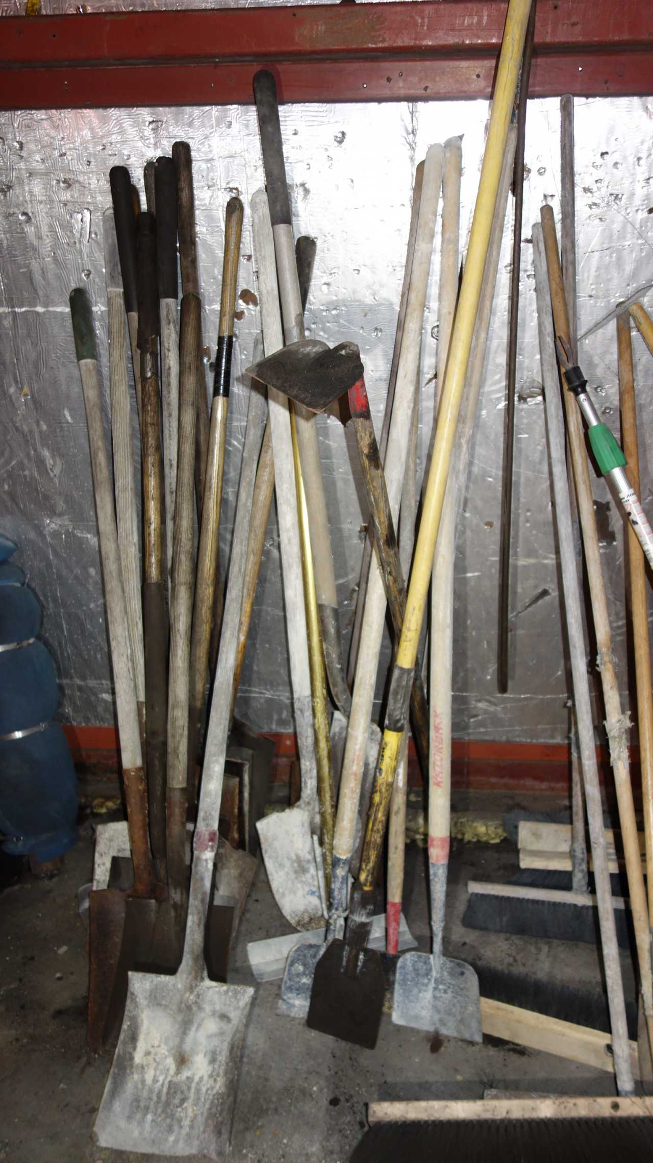 LOT OF BROOMS, SHOVELS, HOES AGAINST WALL - ELECTRIC POWER TOOLS