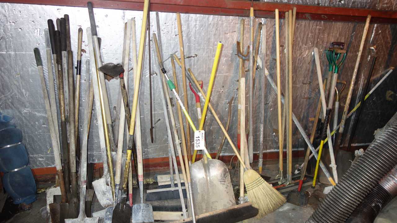 LOT OF BROOMS, SHOVELS, HOES AGAINST WALL - ELECTRIC POWER TOOLS